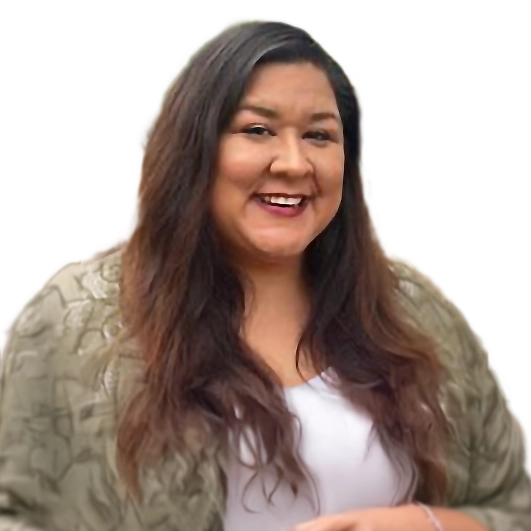 A woman with long brown hair, wearing a light green patterned jacket over a white top, smiles while standing against a plain background.