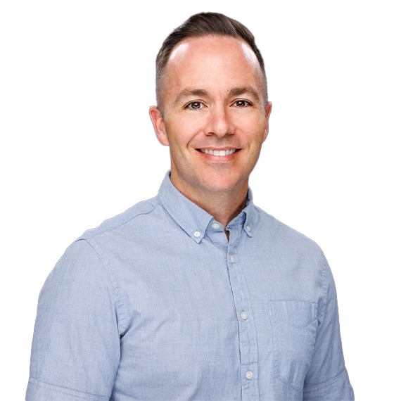 A smiling man with short brown hair wearing a light blue button-up shirt, standing against a dark gradient background.