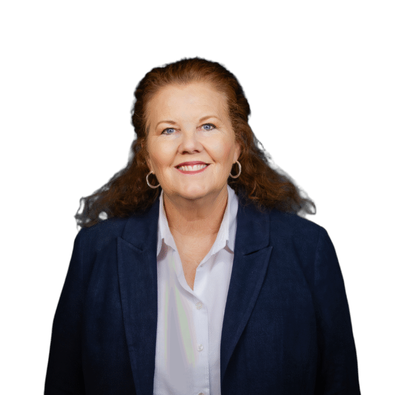 A woman with long brown hair wearing a black blazer and white blouse smiles at the camera against a gradient dark background.